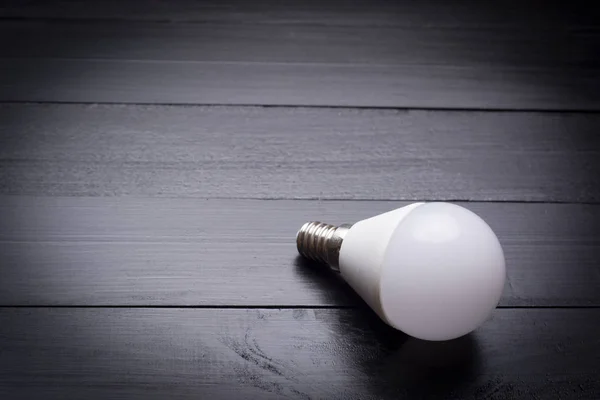 Led bulb on wooden table — Stock Photo, Image