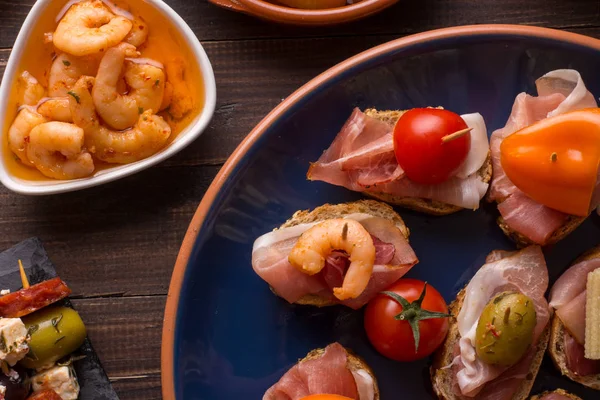 Antipasti di tapas spagnole su tavolo di legno — Foto Stock