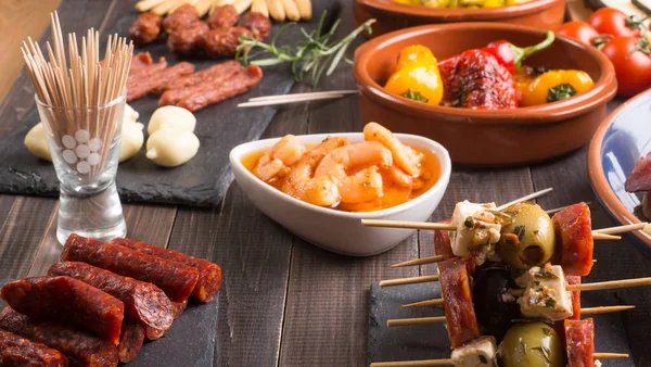 Spanish tapas appetizers on wooden table — Stock Photo, Image