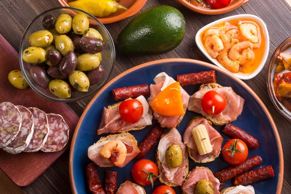 Spanish tapas starters on wooden table — Stock Photo, Image