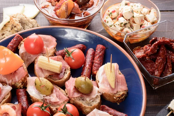 Voorgerechten met prosciutto-ham op blauwe plaat — Stockfoto