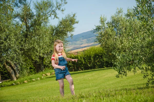 Verano jugar pequeña chica rubia hermosa en la hierba verde — Foto de Stock