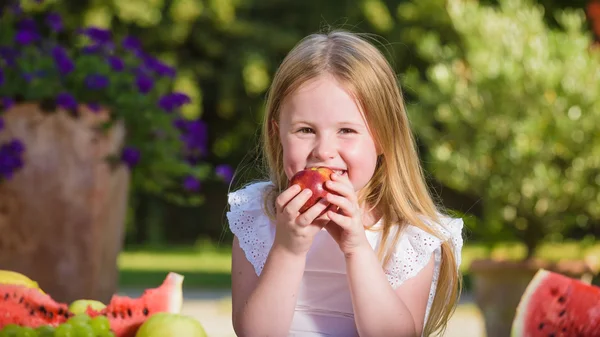 Ovocný úsměv dívku jíst vitamín v podobě nektarinek. — Stock fotografie