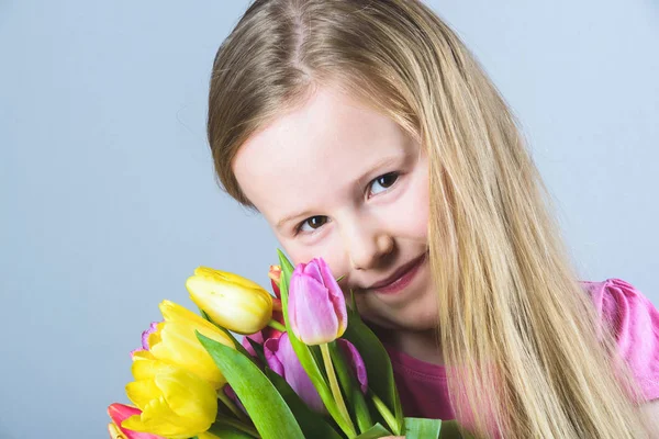 Usmívající se blondýnka s kyticí tulipánů. — Stock fotografie