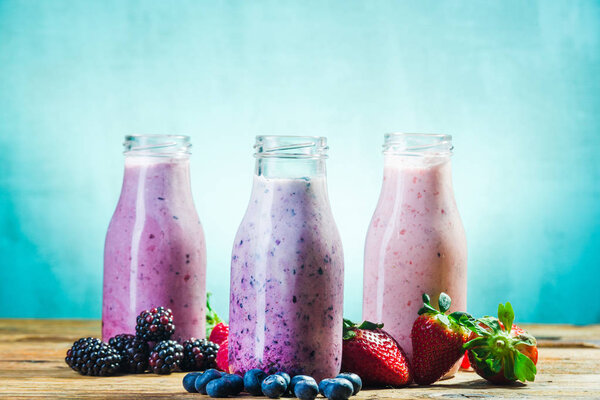 Bottles of fruits yogurt with fresh fruits.