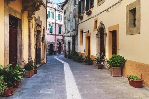 Jalan-jalan di kota Tuscan tua. Bunga-bunga berwarna mekar — Stok Foto