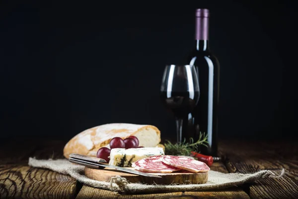 Vinho tinto em luz vintage com queijo e frutas . — Fotografia de Stock