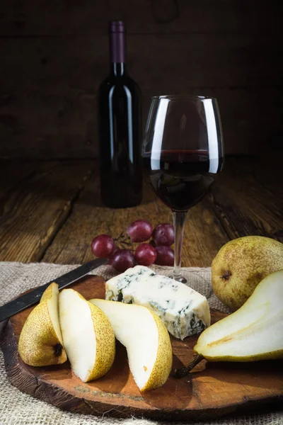 Vinho tinto em luz vintage com queijo e frutas . — Fotografia de Stock