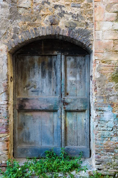 Starý opuštěný dveře v Montalcino, Toskánsko. — Stock fotografie