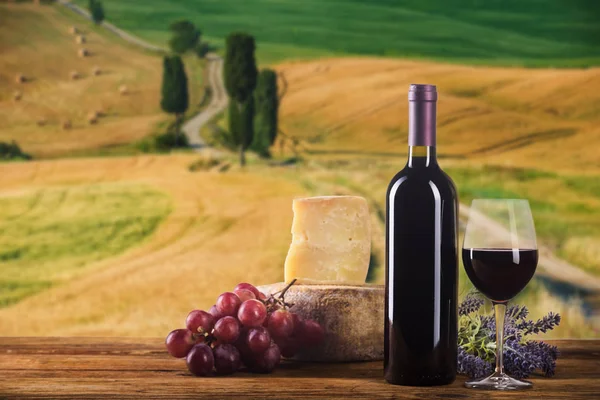 Rött vin i årgångsljus med ost och frukt. — Stockfoto