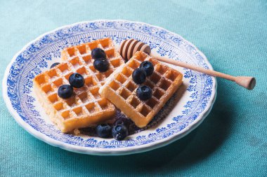 Yaban mersinli taze waffle ve bal.