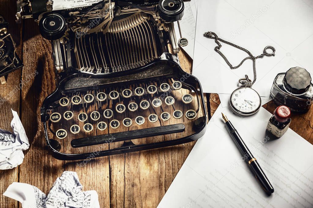 Text prescribed on a vintage typewriter and watch timekeeper.