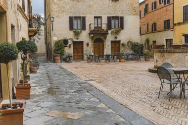 Yağmurlu bir günde güzel şehir Pienza, Toskana 'nın sokaklarında yürü.