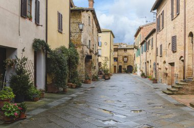 Yağmurlu bir günde güzel şehir Pienza, Toskana 'nın sokaklarında yürü.