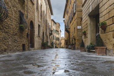 Yağmurlu bir günde güzel şehir Pienza, Toskana 'nın sokaklarında yürü.