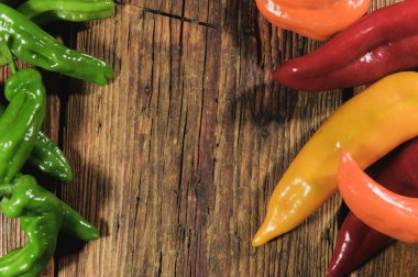 Ahşap bir masanın üzerinde inanılmaz renkli ve kokulu kırmızı biber..