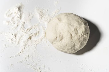 Ezilmiş ve hazırlanmış pizza hamuru, pasta, ekmek masada.