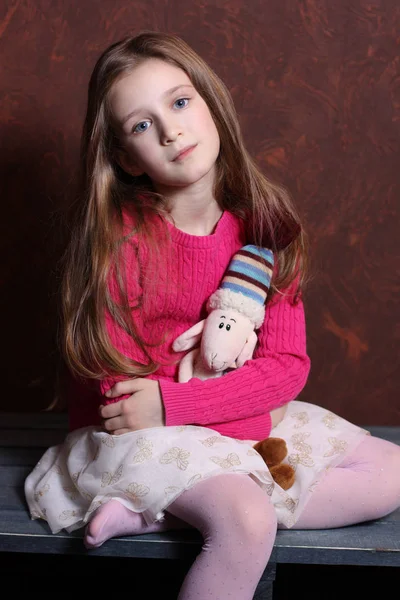 Moje oblíbená hračka. Roztomilá holčička s modrýma očima objímá hračku a sny nebo je smutná. — Stock fotografie