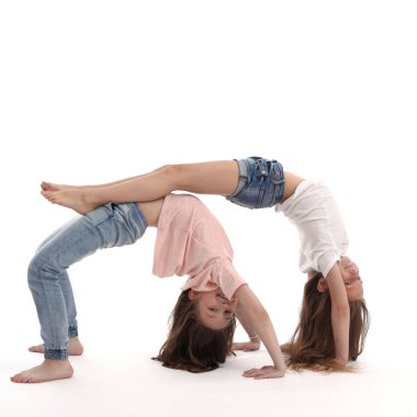 İki kız evde jimnastik yapıyor. Boş vakitlerinde eğleniyorlar. İzole edilmiş arkaplan.