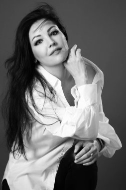 Güzel surat. Güzel bir kadın, 40 yaşında, sağlıklı, pürüzsüz bir teni var. Siyah saçlı, açık renk gözlü, beyaz gömlekli, koyu tenli. Siyah beyaz fotoğrafçılık. Portre