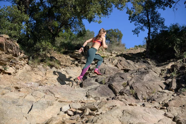 Sportnő fut fel egy sziklákkal teli hegyi ösvény, miközben ő napi edzés — Stock Fotó