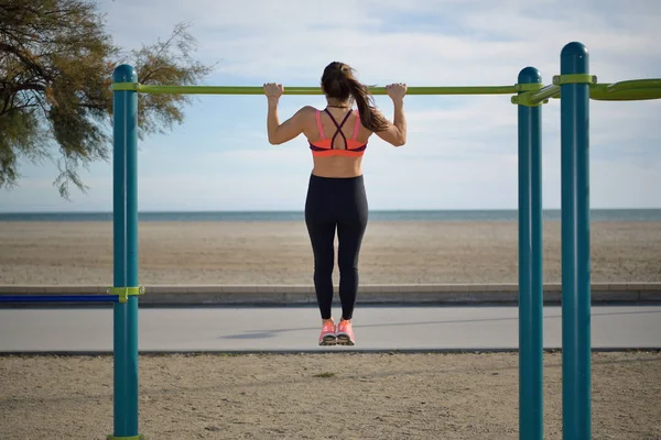 Női atléta húzza fel részeként a szabadtéri fitness gyakorlatok a tenger közelében — Stock Fotó