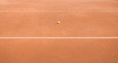 Tenis kortunda terk edilmiş bir tenis topu. Yatay çizgiler arasında tenis topu. Eşleşme yok.