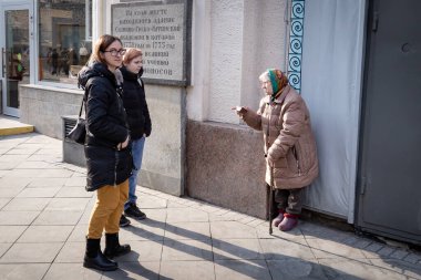 Yaşlı kadın şehir merkezindeki sokaktaki genç kızlara tavsiye veriyor. Moskova, Rusya. Sokak fotoğrafı, gazetecilik..
