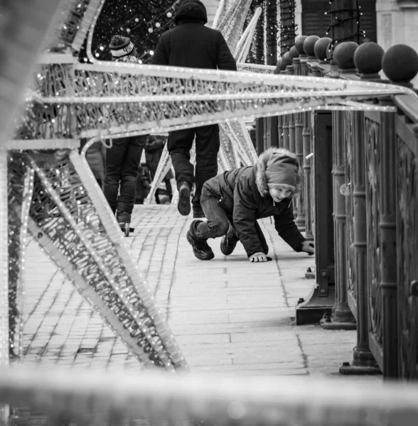 Mutlu çocuk Moskova nehri üzerindeki köprüde oynuyor. Sokak fotoğrafı, gazetecilik..