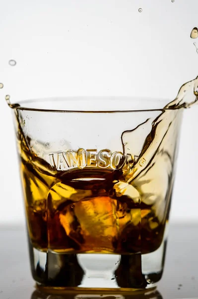 把威士忌倒在后座的杯子里 — 图库照片