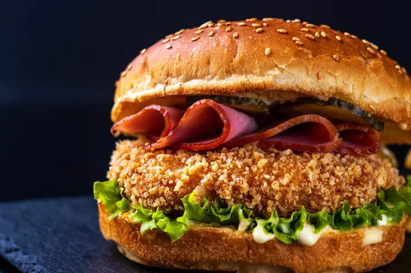 hamburger with bacon on black background