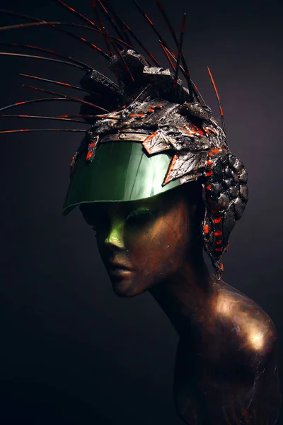 Bronze head of mannequin in decorated bronze helmet, dark studio background