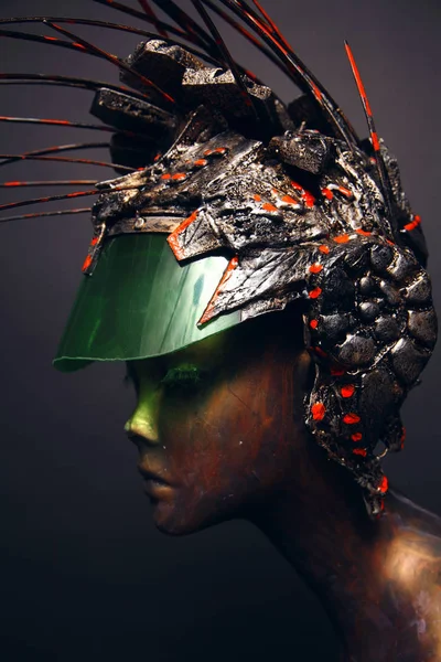 Bronze head of mannequin in decorated bronze helmet, dark studio background