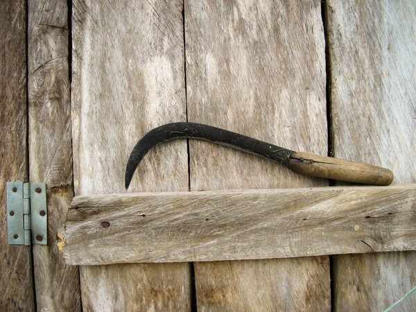 Античный серп на деревянном фоне. старый стальной серп положить на собранный рис. локальный инструмент Ирана. Сельскохозяйственный инструмент. Пыльный и ржавый серп. Закрыть
.