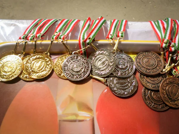 Golden, silver, bronze sports medal with red, white and green ribbon. Winner awards. Translation of the text on medals are \