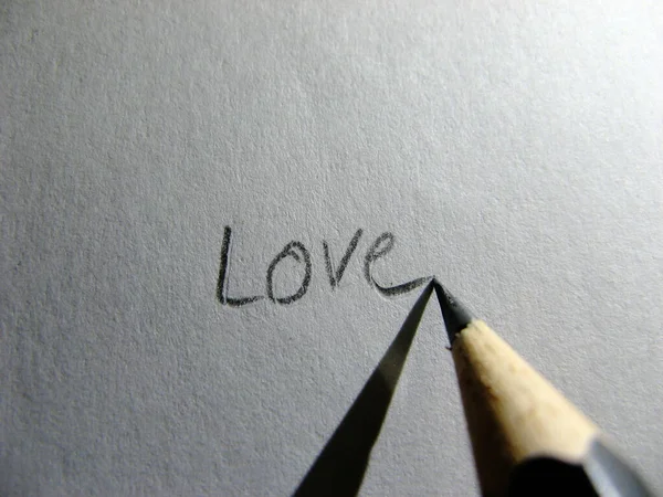 Writing love with pencil on paper.