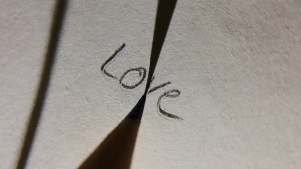 紙のマクロショットに鉛筆で愛を書く回転旋回 — ストック動画
