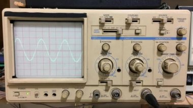 Osiloskop ile çalışan elektronik aletler ve osiloskopta gösterilen sinüs dalgası