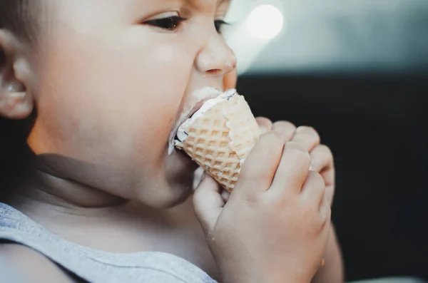 A little child eats ice cream