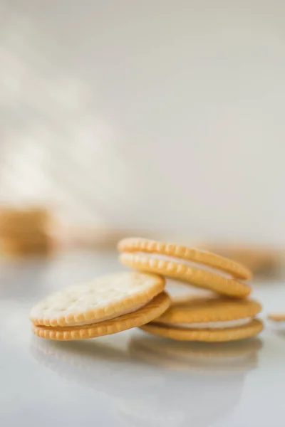 A round cookie with white filling on a light background