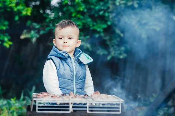 a small child on their own barbecue on the grill helps