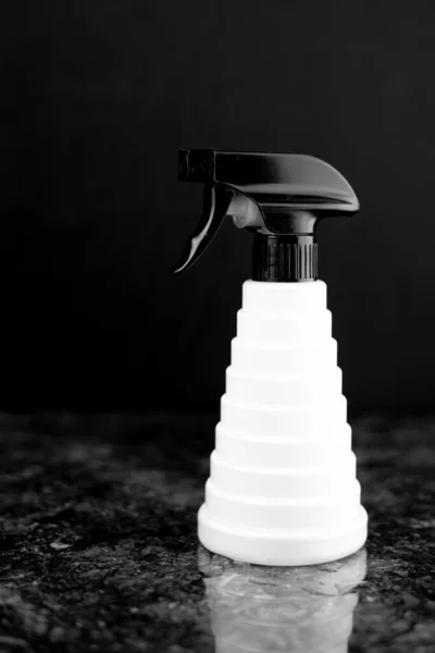 hairdressing spray gun is located on a black marble slab, with black and white colors on a background