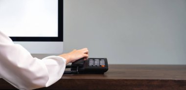 Telefonu tutan kadın ve ofis masasında çalışan bilgisayar..