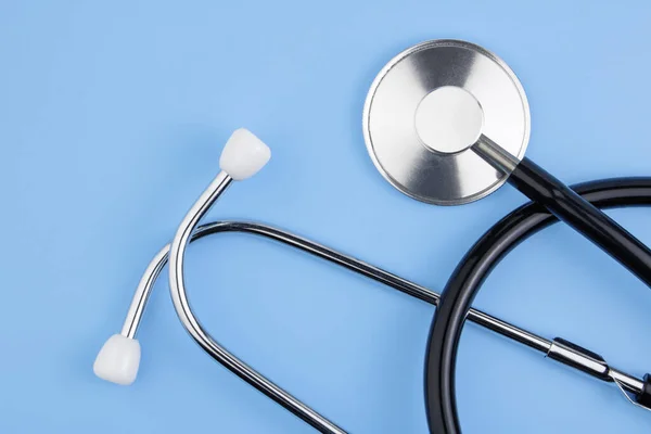 A stethoscope is isolated on a blue background. The concept of medical equipment, cardiology, lung diagnosis, coronavirus, diagnosis of pneumonia. Copy space