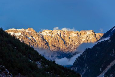 Güneş ışınlarıyla aydınlatılan sıradağların manzarası..