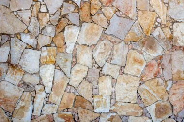 Evin duvarının yüzeyi farklı boyutlarda taş parçalarından yapılmıştır. Doğal renk. Doku.