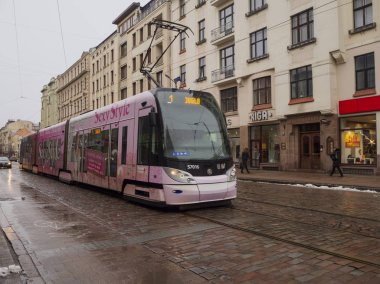 Yağmurdan sonra yağmurlu bir ocak günü Riga caddesinde pembe tramvay. 2020-01-06, Riga, Letonya.