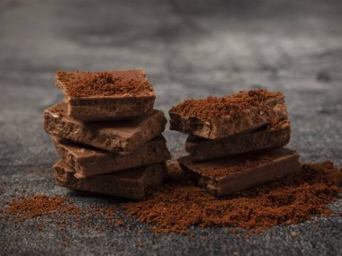 Kırık çikolata parçaları üzerine kahve tozu serpiştirilmiş..