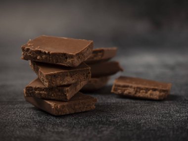 Kırık kahve parçacıkları gri taş arka planda kapanıyor..