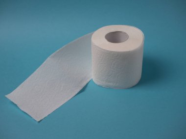 Beyaz delikli iki katmanlı tuvalet kağıdı. Mavi arka planda izole edilmiş, fotokopi alanı ile yakın plan..